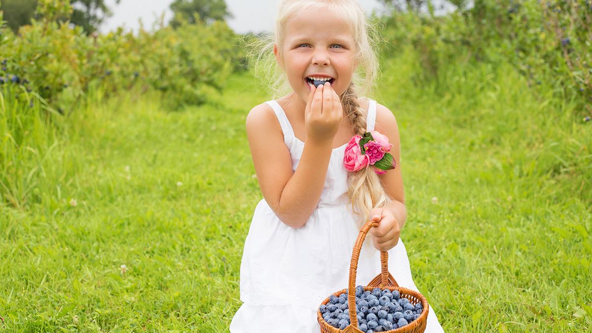 girl eating blueberries
