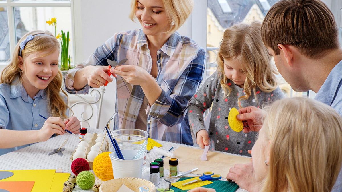 Cheerful family having fun painting and decorating easter eggs.