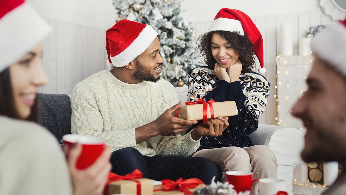man surprising woman with Christmas gift