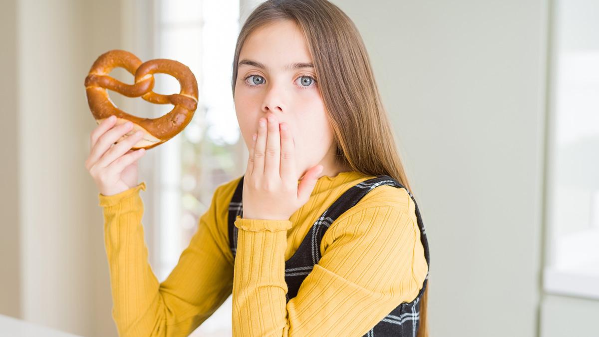 a girl eating a pretzel