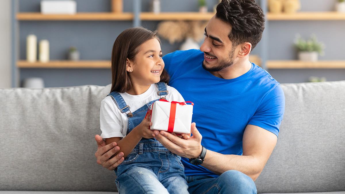 father giving gift to daughter on International Day of Charity