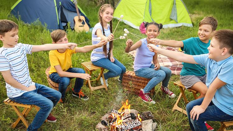 summer birthdays with kids roasting marshmallows while camping out