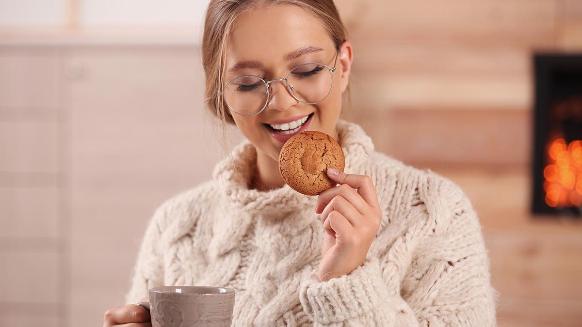Photo of a woman enjoying a cookie and tea