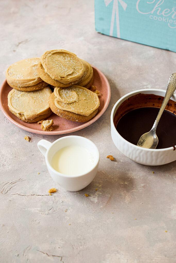 cookie pops with cookies on a plate with melted chocolate and milk