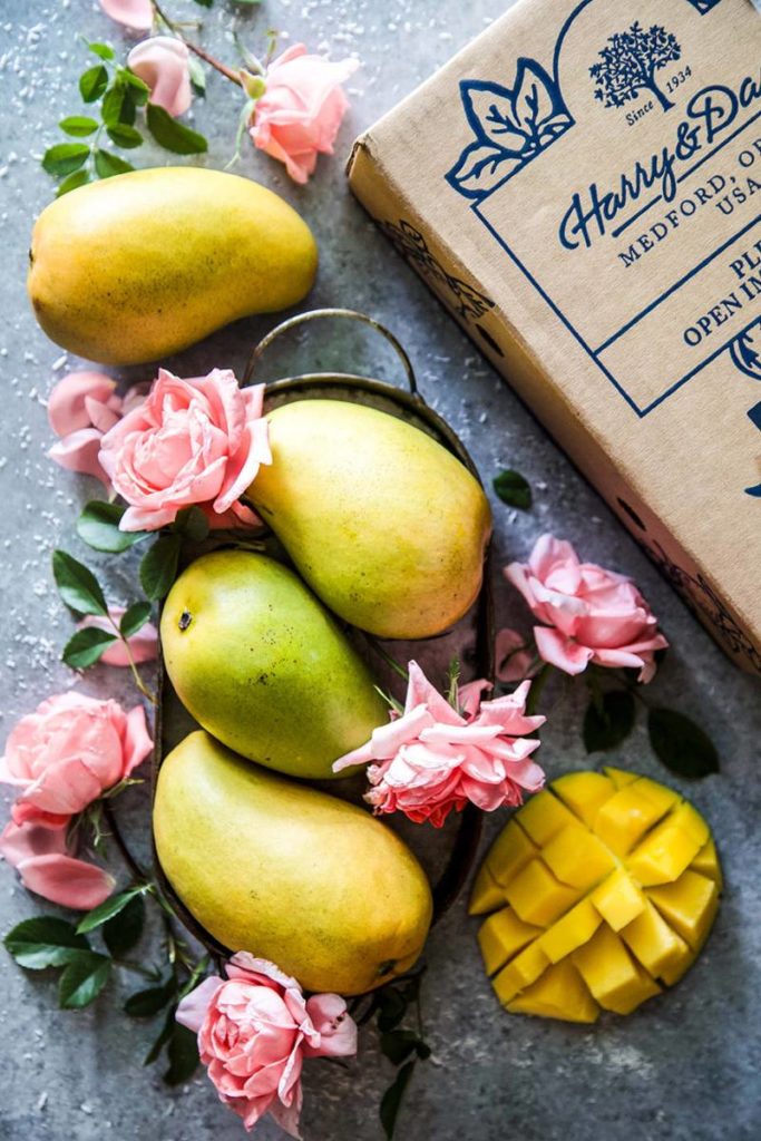 Harry & David Mangos on a counter surrounded by flowers