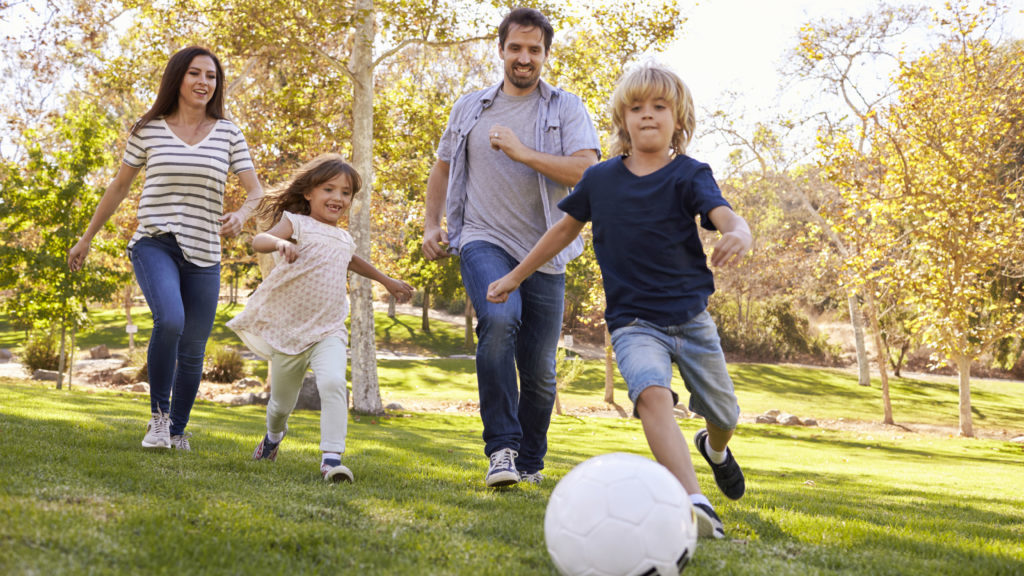 Summer bucket list item of a family playing soccer