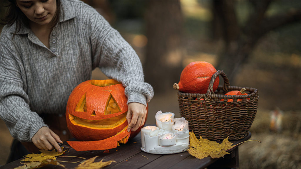 Photo of a woman carving a pumpkin