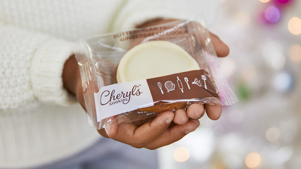 History of Christmas cookies with a cookie wrapped in plastic being held in a child's hand.