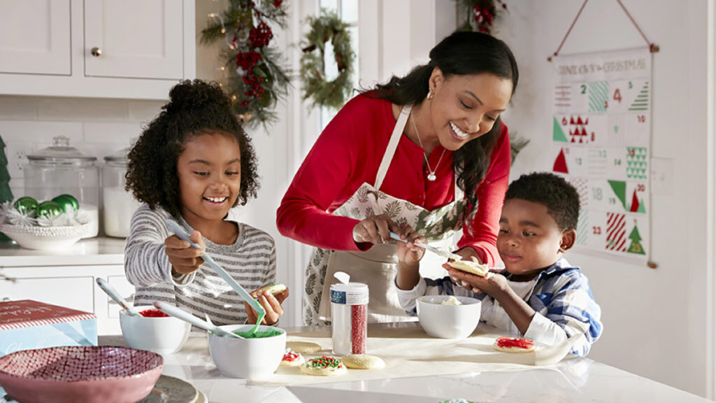 History of Christmas cookies with a family decorating cookies in a kitchen.