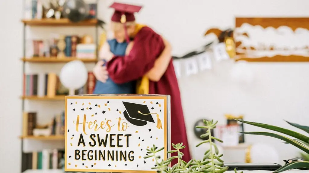 graduation party ideas graduate wearing a cap and gown hugging a parent.