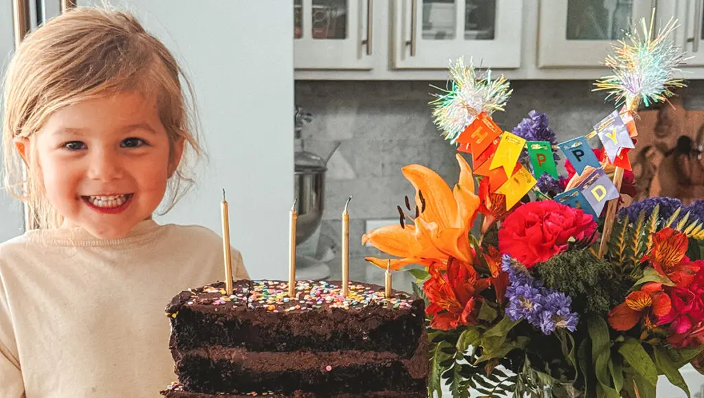 half birthdays young girl blowing out candles on a half birthday cake.